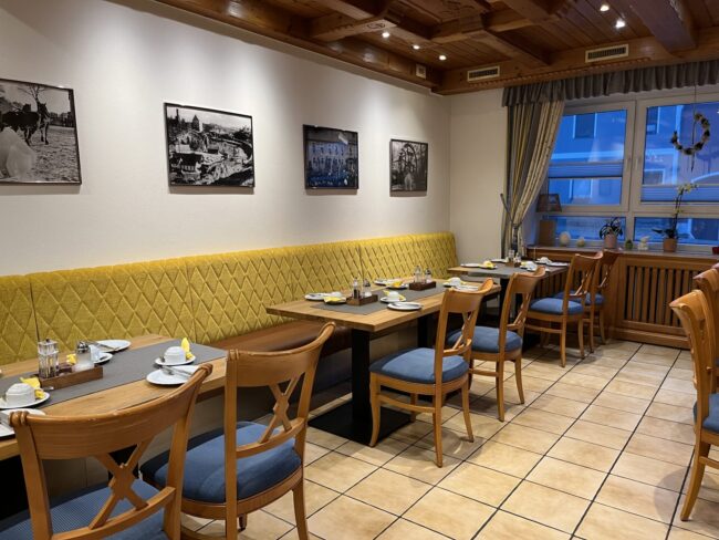 Frühstücksbereich mit Tischen und Stühlen in gemütlichem Ambiente