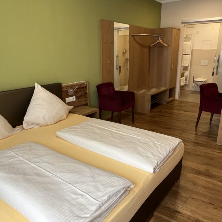 Blick ins Business Doppelzimmer mit Doppelbett und Schank, sowie Schreibtisch