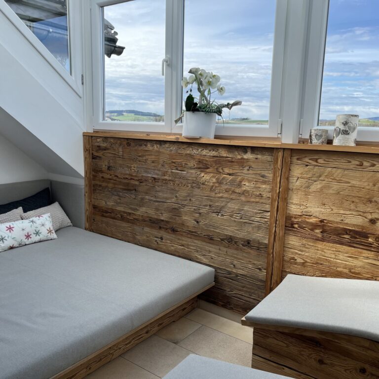 Saunabereich vom Hotel Waldnaabtal mit grauen Polstern und Holzverkleidung an der Wand